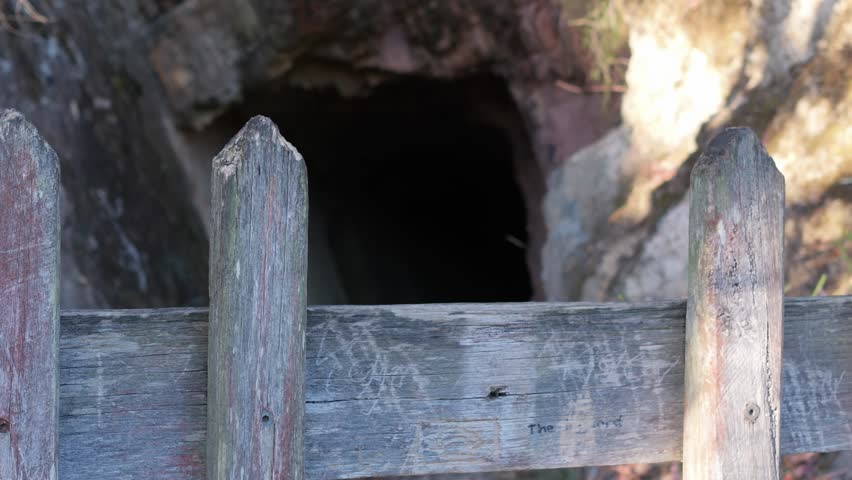 Explore a historic mining entrance in Warrandyte, Melbourne, surrounded by rugged wooden fences. The scene is captured in natural daylight, showcasing rustic textures.