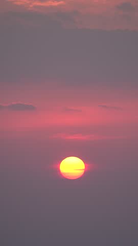 The bright red sun rising in the morning sky