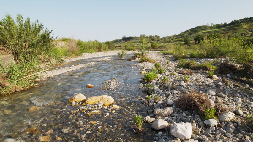 Small river with water flowing in decreasing quantities during drought