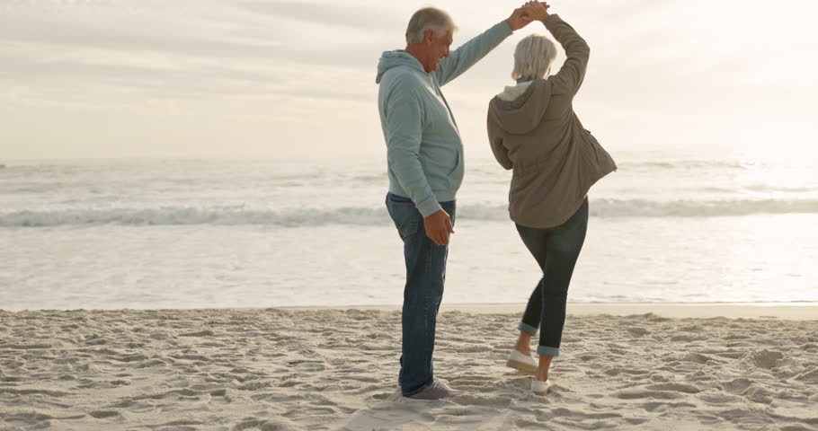 Love, dance and sunset with old couple at beach for travel, summer vacation and anniversary getaway. Support, holding hands and retirement with senior people for holiday, bonding and romance together