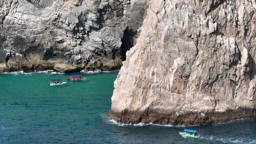 Drone Shot Of Boats Sailing In Front Of Huge Natural Rocks Formation In Los Cabos Baja California, Mexico