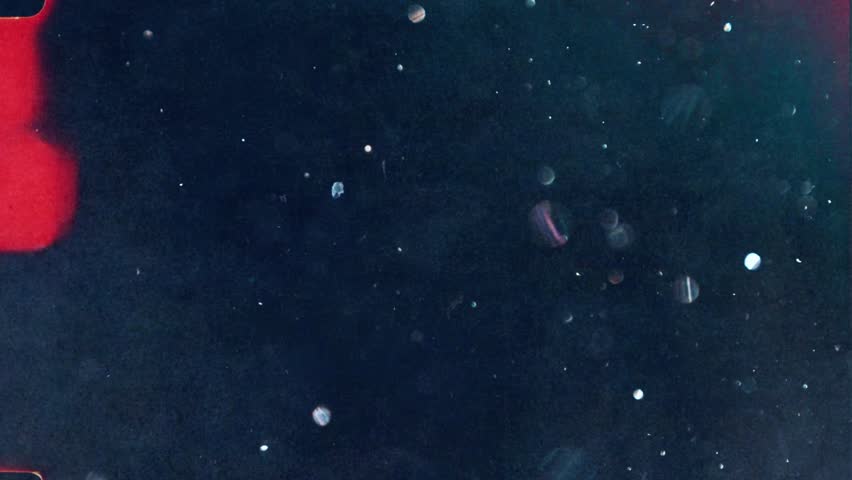 Glitter dust particles floating in dark water