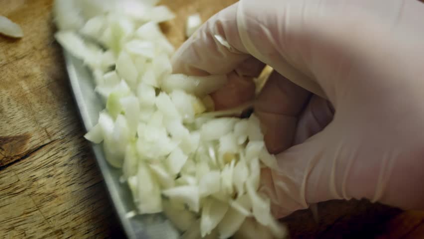 Diced onion being placed on a serving plate