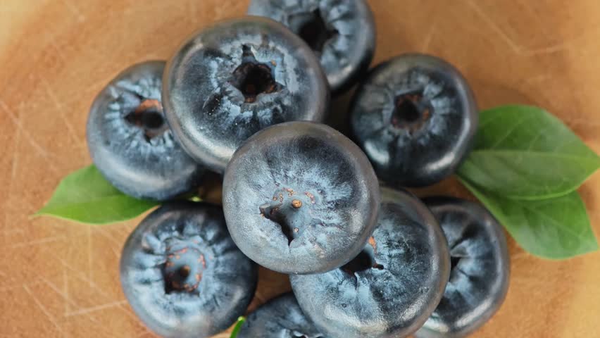 Fresh blueberries on wooden board. Rotation.