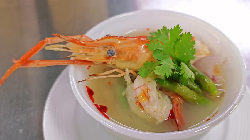 Close up of healthy Thai spicy shrimp soup (Tom Yum Kung) garnished with fresh coriander.