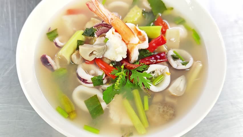 Delicious hot and sour Thai seafood soup with river prawn and chili oil droplets.