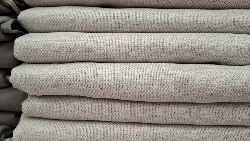 Household blankets or plaids arranged in tidy piles. Modern housekeeping, interior design trends, and premium home decor accessories in stores or specialty textile boutique