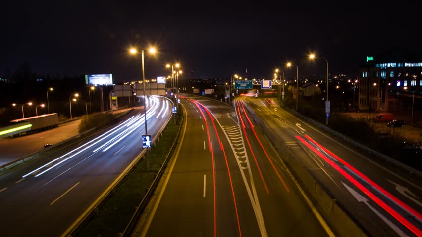 Night time lapse of highway traffic with long exposure light trails. Static camera shot from a bridge