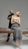 Professional neck and shoulder massage session with a therapist assisting a relaxed client wrapped in a towel on a massage table, demonstrating soothing techniques in a calm studio - Powered by Shutterstock - Get 15% off with code: PIKWIZARD15