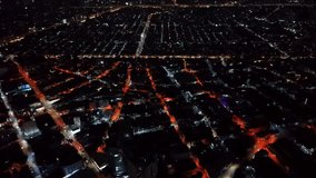 From an extraordinary altitude a night aerial perspective transforms the dense urban fabric of Metro Manila into something resembling an illuminated circuit board. Streets lit by amber sodium lamps form a glowing geometric grid that stretches in every direction across the frame. Between these luminous pathways dark rectangular blocks of low to mid-rise buildings create a repeating pattern of shadow and light. The drone rotates slowly during the capture causing the entire grid orientation to shift gradually and adding a hypnotic quality to the visual experience. Larger arterial roads cut through the regular grid at diagonal angles their brighter illumination standing out against the finer residential street network. The sheer scale of visible urban sprawl extends far toward every edge of the frame conveying the massive footprint of this Southeast Asian metropolis. At this extreme altitude individual vehicles become nearly invisible and the city reduces to pure geometry where human infrastructure reveals its underlying mathematical order. The amber color palette dominates with occasional pockets of whiter or cooler light marking newer LED installations among the older sodium fixtures. Dark voids between structures hint at narrow alleys and interior courtyards invisible from street level but clearly legible from this overhead vantage. - Powered by Shutterstock - Get 15% off with code: PIKWIZARD15