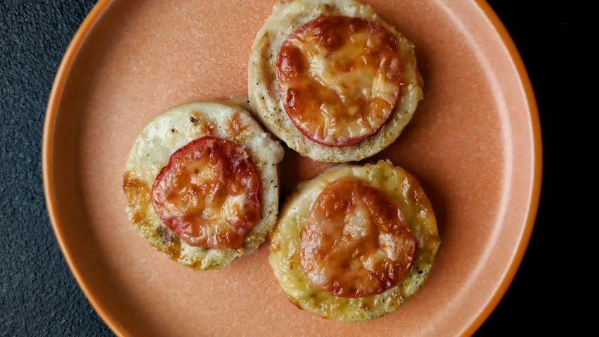Round fish or chicken cutlets baked with tomato and cheese. Fish cutlets as a food backdrop for your design