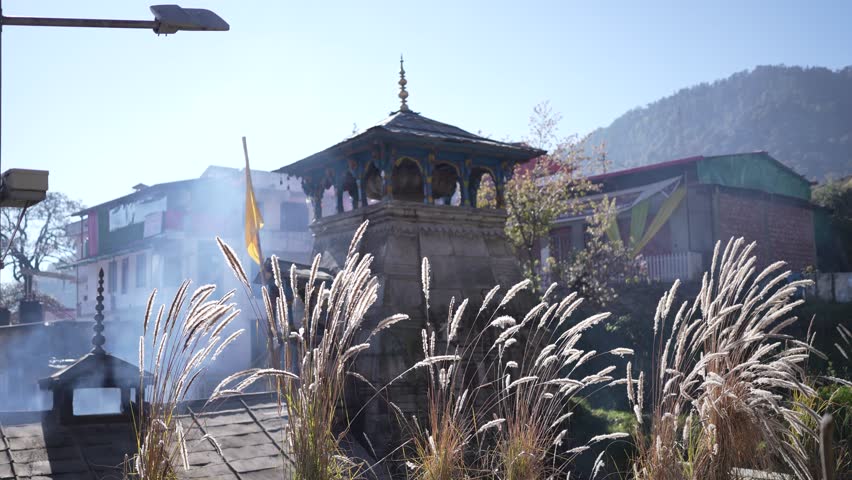 Wide angle side view of Triyuginarayan Temple in Uttarakhand, India. Ancient Hindu pilgrimage site surrounded by Himalayan mountains with scenic landscape and spiritual significance.