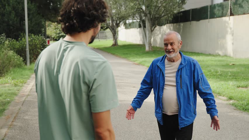 Senior father and adult son hugging with emotion showing strong family bond 