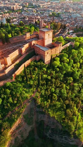 Aerial view of the historic Alhambra palace at sunset in Granada, Andalusia, Spain. The ancient Arabic fortress Alhambra during the beautiful evening. Aerial drone footage of Granada cityscape