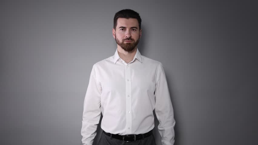 Handsome man in shirt posing on grey background
