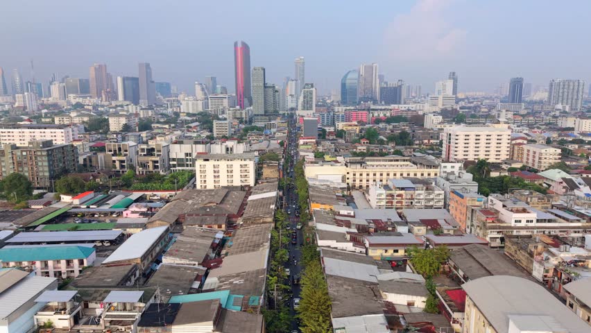 Aerial view of Bangkok city skyline with busy traffic road and urban buildings. Modern cityscape and daily life in Thailand, Southeast Asia.