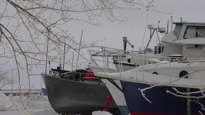 Fishing ships boats in winter drying in a dock outside covered in snow