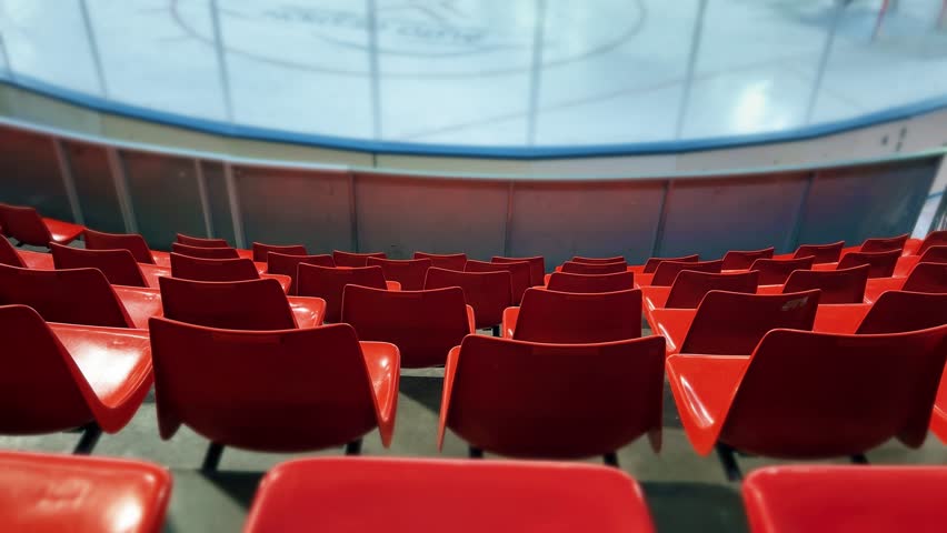 Empty Red Arena Seats Facing Ice Rink During Hockey Training or Match