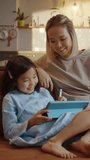 Happy mother and child using tablet together for digital learning at home. Smiling kid drawing or writing with stylus while parent supports and guides the process. Concept of joyful education, family - Powered by Shutterstock - Get 15% off with code: PIKWIZARD15