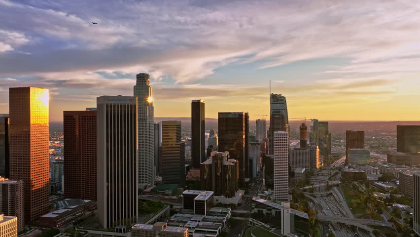 Los Angeles skyline at sunset. LA skyscrapers in dusk. Aerial view Los Angeles cityscape. Los Angeles skyline at dusk. Aerial flight above downtown LA. Glowing skyscrapers in Los Angeles.