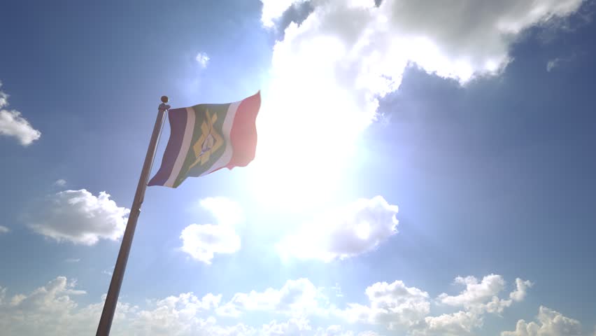 Johannesburg Flag (South Africa) waving on a Flagpole from a Moving Angle in front of a blue sky with clouds