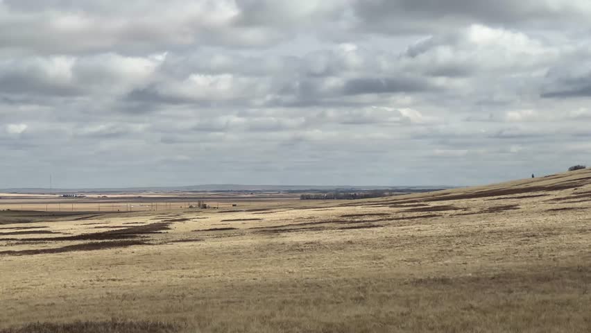 Expansive prairie landscape views in Alberta Canada with open fields and wide horizon under blue sky
