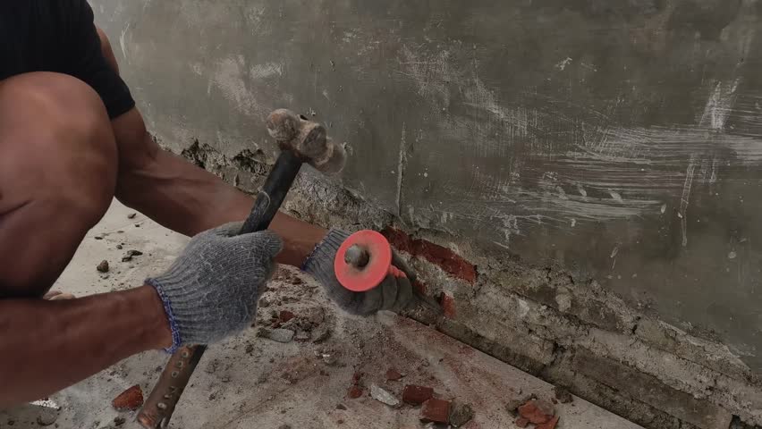 Manual Worker Using Hammer to Break and Chip Concrete Wall Surface