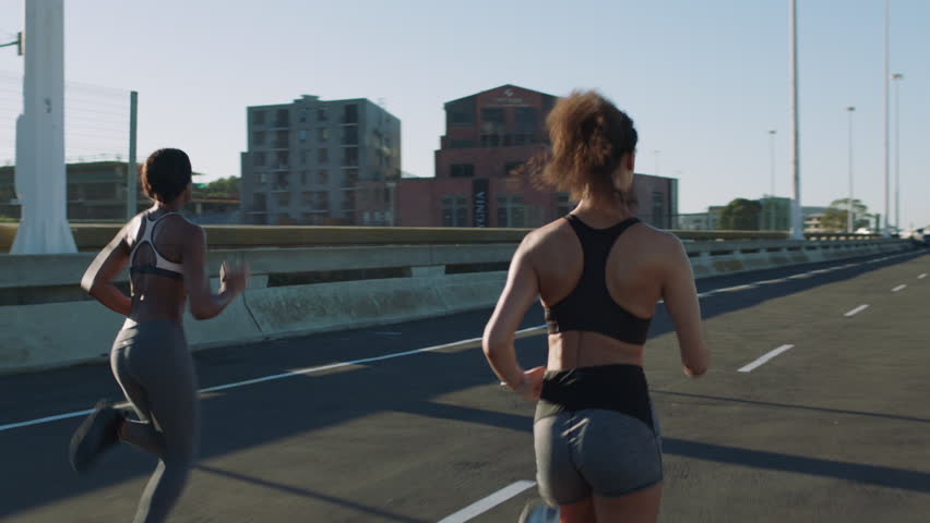 Running, training and people in city, friends and exercise for health benefits, support and challenge. Energy, men and women in street, cardio workout and fitness for wellness, endurance or speed
