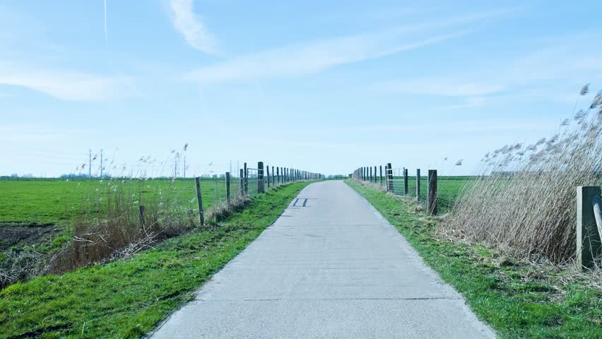 Point of view walking on a narrow country road through fields