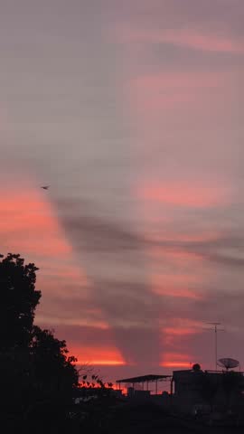 Dramatic Sunset Sky with Silhouette of Urban Rooftops and Trees