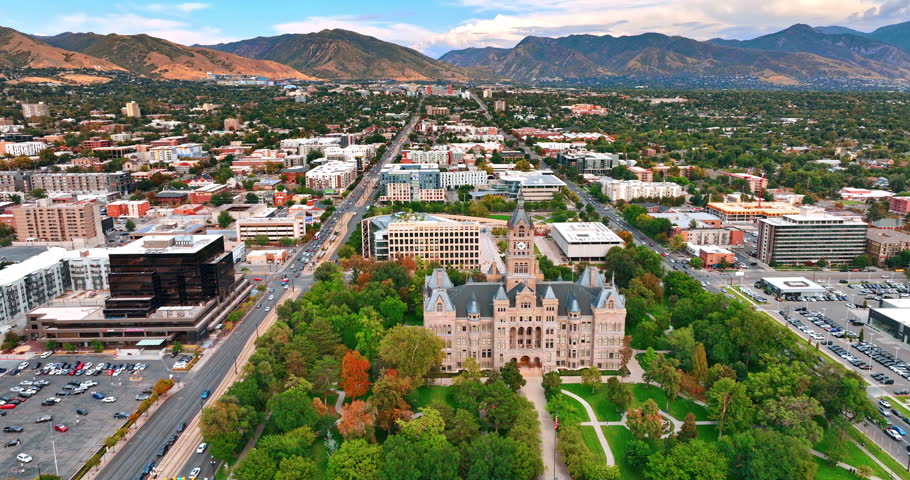 Flying over the Salt Lake City and County Building in Salt Lake City, Utah, USA. Beautiful mountain range at backdrop.