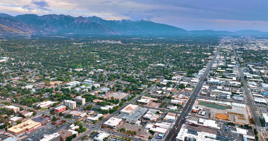 Vast urban landscape with lush greenery. Beautiful rocks at the backdrop. Salt Lake City, Utah, USA. Aerial view.