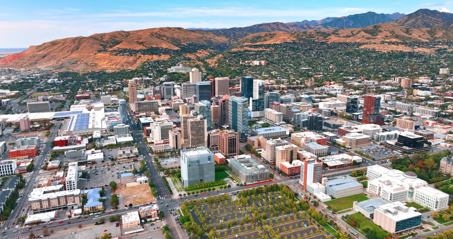 Modern urban landscape at the foot of the mountains. Rising over the cityscape of Salt Lake City, Utah, USA at day.