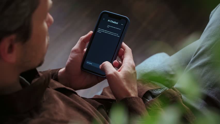 Close up of a man holding a smartphone, using an AI chatbot app for work, brainstorm a business project. Personal Artificial intelligence assistant helping with productivity. Space for text