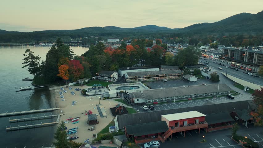 Adirondack Mountain, New York State. Aerial view of a coastal town during autumn, with a lake and mountains in the background.