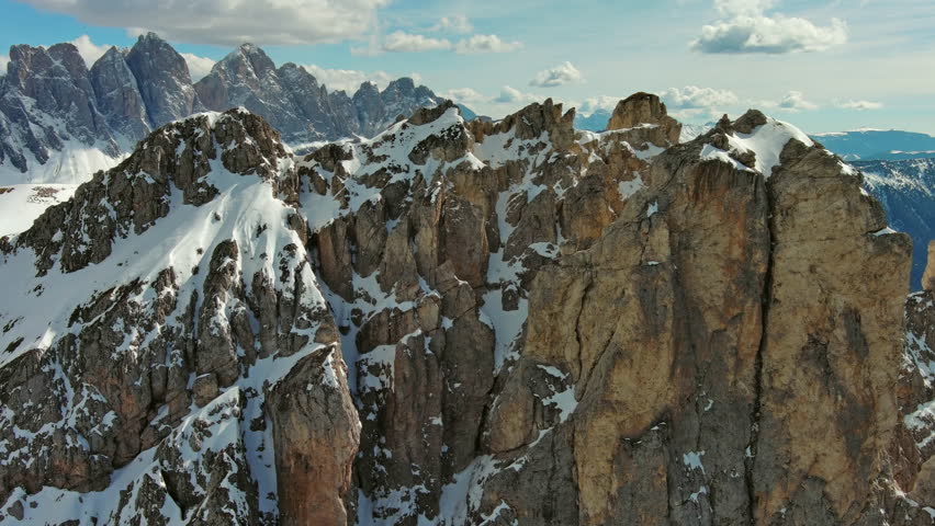 Aerial around view of majestic rocky mountains in snow Alps, Dolomites, Italy, 4k