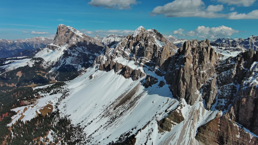 Aerial view of majestic rocky mountains in snow Alps, Dolomites, Italy, panorama 4k