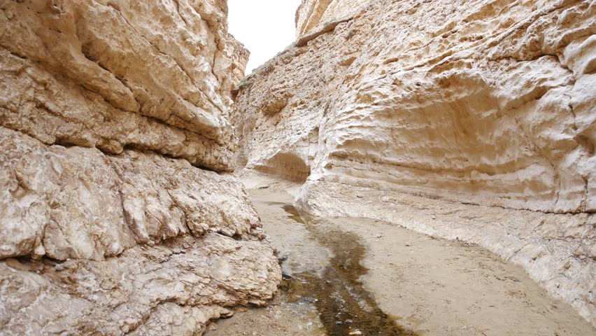 Narrow rock corridor in Mides Canyon, southern Tunisia, with layered sandstone walls, highlighting erosion patterns, geological textures, and a remote landscape ideal for travel and nature concepts