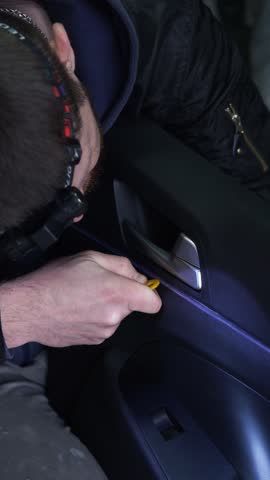 male craftsman inserts a backlight into a car door, installing a car backlight, professional service, tuning