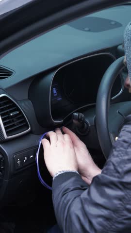 professional do-it-yourself car repair. male craftsman inserts backlight into dashboard of car, installs backlight, disassembled car, service, tuning