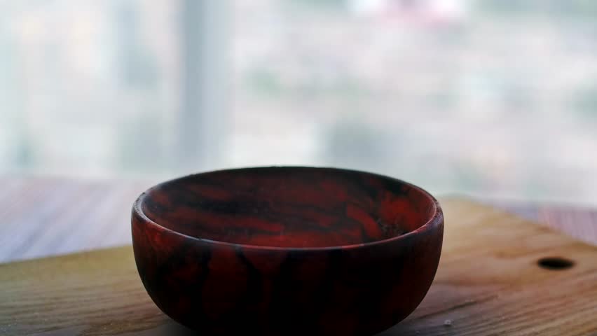 Sea salt crystal falls into a wooden plate, harmful to health. White death or cure