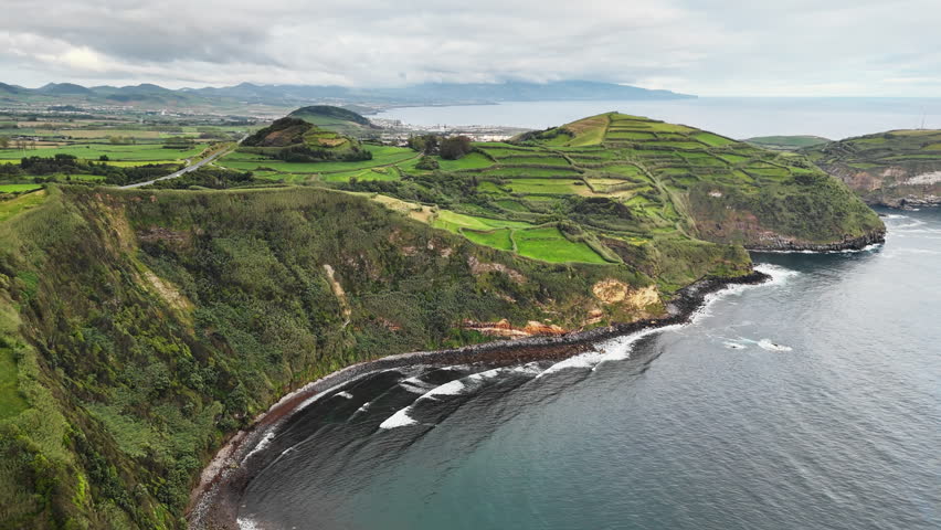 Aerial view of rural agricultural landscape on rugged volcanic coastline in Azores, Portugal.