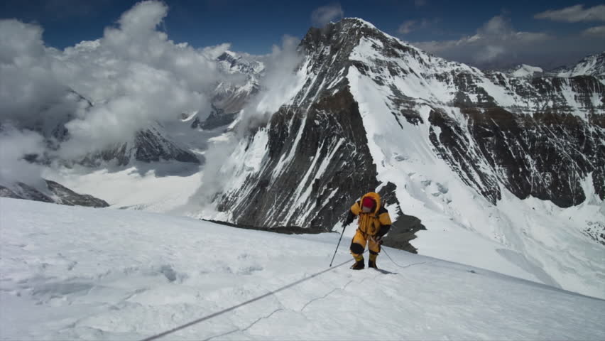 Professional mountaineer walking on a high altitude snowy ridge in the Himalayas