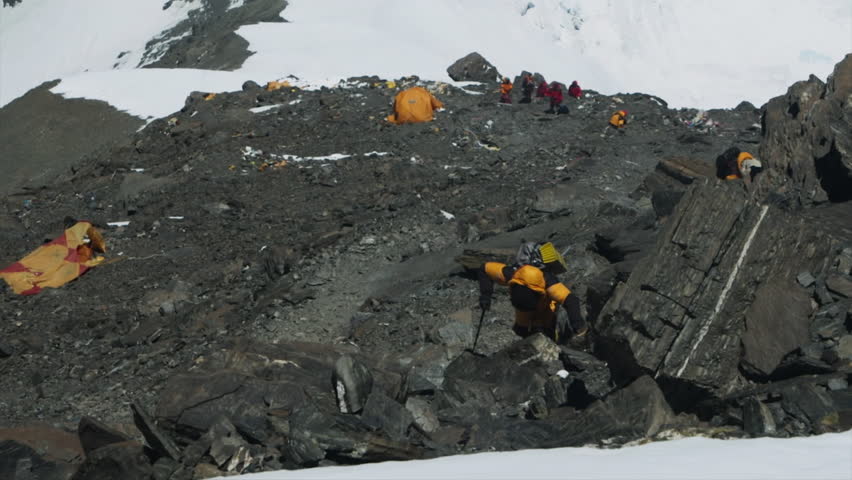 Aerial view of a climber navigating a difficult rocky path near a high altitude camp on Everest