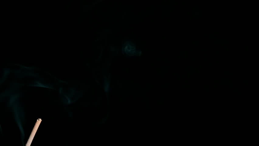 Close up of aromatic incense glowing and releasing gentle smoke plumes