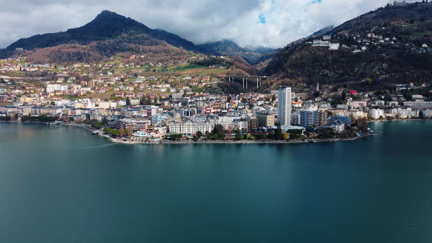 Pull out drone shot of Montreux cityscape with Lake Geneva during the day in Canton of Vaud, Switzerland