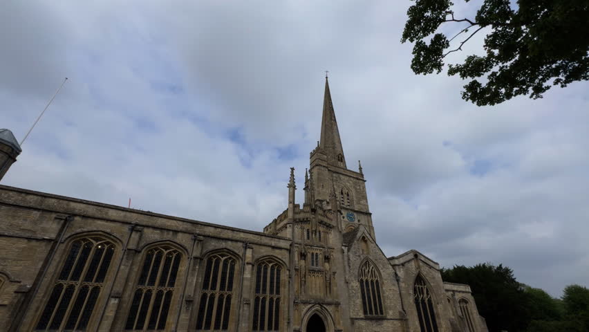 Fixed-angle video of a Gothic stone church and aged cemetery in England, highlighting subtle shifts in natural light.