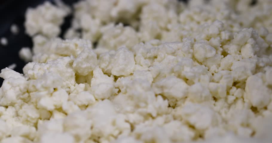 sprinkled with liquid sour cream, lumps of freshly made fermented milk product, close up