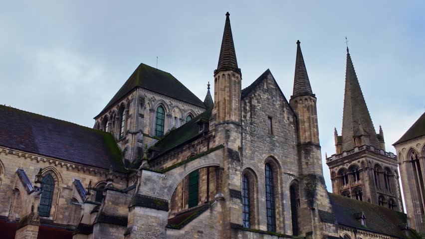 Quick panning shot of the ancient Lisieux Cathedral aka Cathedrale Saint-Pierre de Lisieux church rooftop side, France
