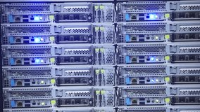 Slow motion of AI server racks blinking with blue LED lights in a dark room, showcasing high-performance computing infrastructure. - Powered by Shutterstock - Get 15% off with code: PIKWIZARD15